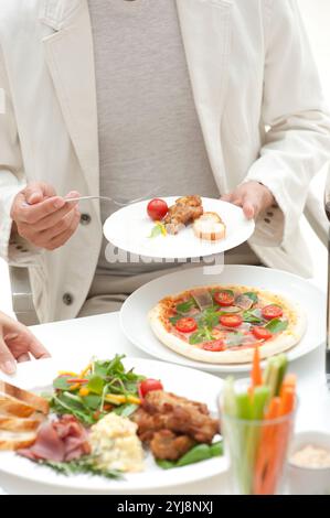 Leute essen Hors d'oeuvres auf einer Hausfeier Stockfoto