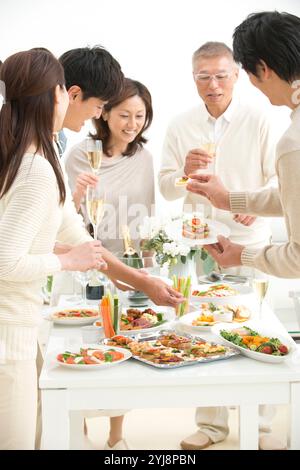 Leute essen Hors d'oeuvres auf einer Hausfeier Stockfoto