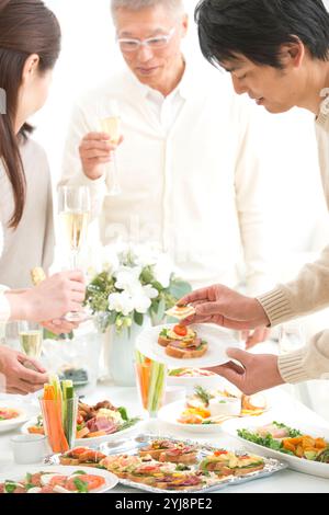 Leute essen Hors d'oeuvres auf einer Hausfeier Stockfoto