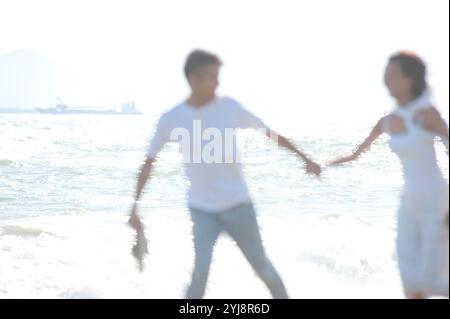 Ein Paar, das barfuß am Meer spielt Stockfoto