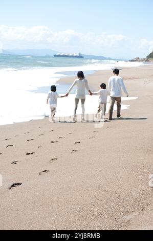 Rückansicht der Familie, die am Meer spaziert Stockfoto