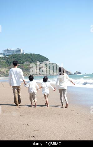 Rückansicht der Familie, die am Meer spaziert Stockfoto