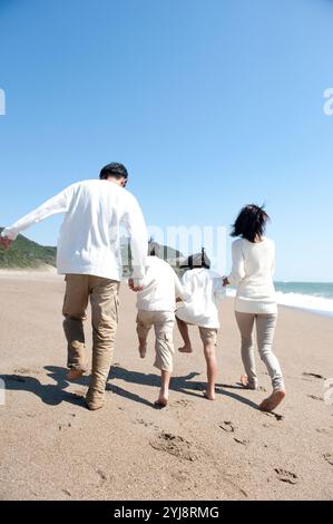 Rückansicht der Familie, die am Meer spaziert Stockfoto