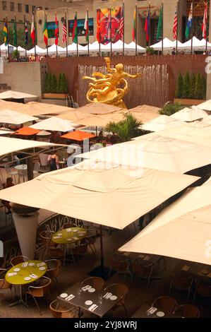 Große Sonnenschirme schützen die Gäste in einem Restaurant am hauptplatz des Rockefeller Center in New York City Stockfoto