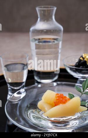Glas-Sake-Becher mit Heringsrogen und schwarzen Bohnen, serviert in Glasgefäßen Stockfoto