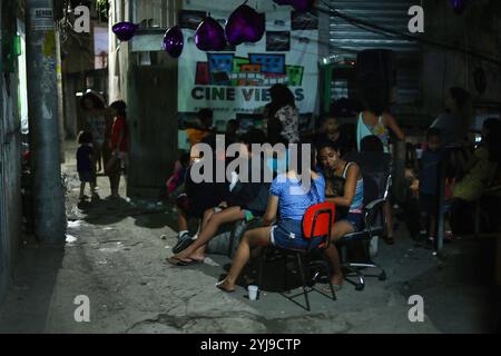 Rio De Janeiro, Brasilien. Oktober 2022. Die Bewohner von Vidigals Favela in Rio de Janeiro sehen sich einen Film an, der auf eine Gasse projiziert wird. Für Menschen, die in den Favelas von Rio de Janeiro, Brasilien, leben, ist ein Filmbesuch ein teurer und abgelegener Zeitvertreib. Jede Woche bietet ein assoziativer Filmclub eine Open-Air-Vorführung in der Vidigal-Favela an. Quelle: SOPA Images Limited/Alamy Live News Stockfoto