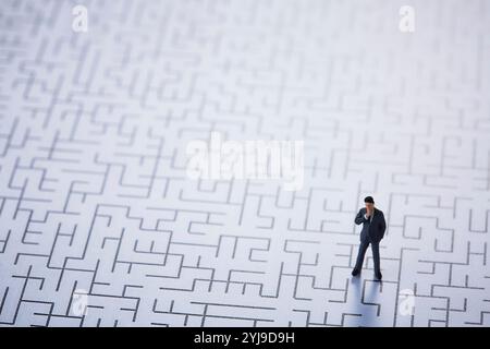 Puppe in Miniatur, die auf dem Labyrinth steht Stockfoto