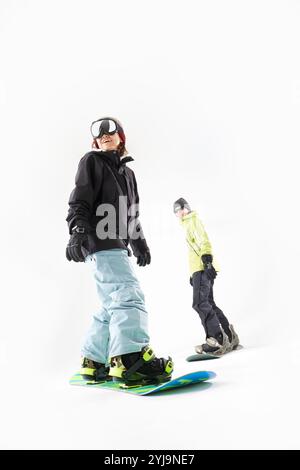 Mann und Frau Snowboarden mit weißen Rucksäcken Stockfoto