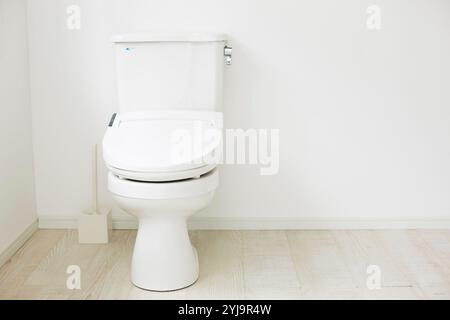 Toilette in einem Raum mit weißem Boden und Wänden Stockfoto