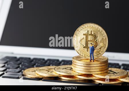 Bitcoins und Miniaturen auf der Tastatur Stockfoto