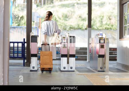 Rückansicht einer Frau, die durch die Bahnhöfe fährt Stockfoto