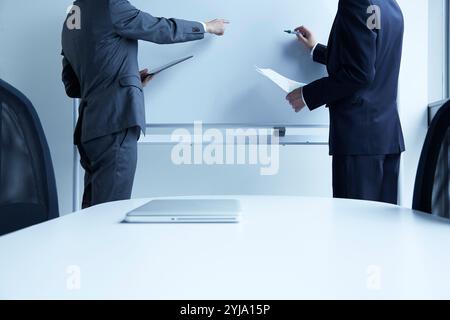 Zwei Männer, die dem Whiteboard zugewandt sind Stockfoto