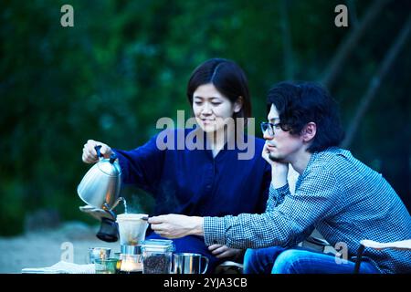 Mann und Frau trinken Kaffee auf dem Campingplatz Stockfoto