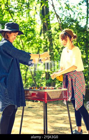 Zwei Frauen grillen Essen auf einem Grillofen Stockfoto