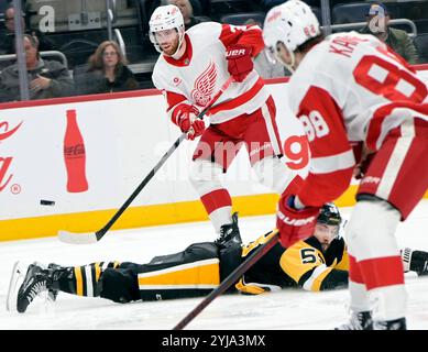 Kris Letang (58) taucht vor Detroit Red Wings Left Wing J.T. Compher (37) während der dritten Phase des Red Wings 3-2-Überstundensiegs in der PPG Paints Arena in Pittsburgh am Mittwoch, den 13. November 2024. Foto von Archie Carpenter/UPI. Stockfoto