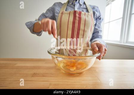 Frau schlägt Eier in der Küche Stockfoto