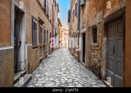 Rovinj, Kroatien - leere enge Straße in der Altstadt von Rovinj an einem sonnigen Sommermorgen mit traditionellen Kopfsteinpflastern, bunten Häusern, Fenstern und Stockfoto