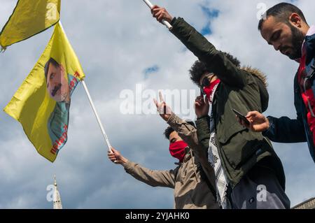 London, Großbritannien. Mai 2018. Kurden halten Flaggen, die Ocalan und die YPG-Verteidigungsstreitkräfte unterstützen, auf einem der Löwen auf dem Trafalgar Square bei der Kundgebung, darunter viele von Londons internationalen und Migrantengemeinschaften, die den Internationalen Arbeitertag feiern. Einige Gewerkschafter und Aktivisten hielten Reden und schlossen ein kurzes Schweigen zum Gedenken an Mehmet Aksoy ein, der in Syrien während der Dreharbeiten mit kurdischen Kämpfern getötet wurde und bei früheren Ereignissen für die Kurden gesprochen hatte. Am Ende der Kundgebung gab es eine Rede von Brixton ritzy Gewerkschafterin Kelly Rogers, die von Picturehouse und The V zum Opfer fiel Stockfoto