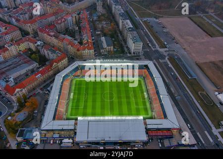 Blick aus der Vogelperspektive auf Sparta Prags Fußballstadion, Tschechien, mit seinem pulsierenden grünen Feld und der umliegenden städtischen Architektur. Stockfoto