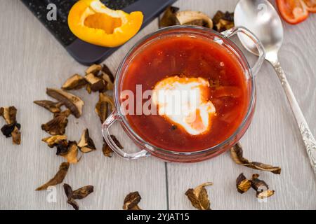 Fastenborsch mit getrockneten Pilzen und Gemüse auf einem hellen Holztisch. Stockfoto