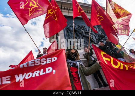 London, Großbritannien. Mai 2018. CPGB-ML, (Kommunistische Partei GB-marxistisch-leninistische Fahnen auf dem Sockel auf dem Trafalgar Square bei der Kundgebung, darunter viele von Londons internationalen und Migrantengemeinschaften, die den Internationalen Arbeitertag feiern. Einige Gewerkschafter und Aktivisten hielten Reden und schlossen ein kurzes Schweigen zum Gedenken an Mehmet Aksoy ein, der in Syrien während der Dreharbeiten mit kurdischen Kämpfern getötet wurde und bei früheren Ereignissen für die Kurden gesprochen hatte. Am Ende der Kundgebung gab es eine Rede von Brixton ritzy Gewerkschafterin Kelly Rogers, die von Picturehouse und den verschiedenen Prekaren zum Opfer fiel Stockfoto