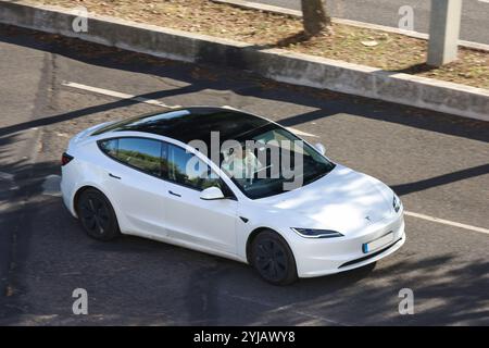 Geschäftsmann fährt unterwegs ein tesla Model 3 Elektroauto mit einem Virtual-Reality-Headset Stockfoto