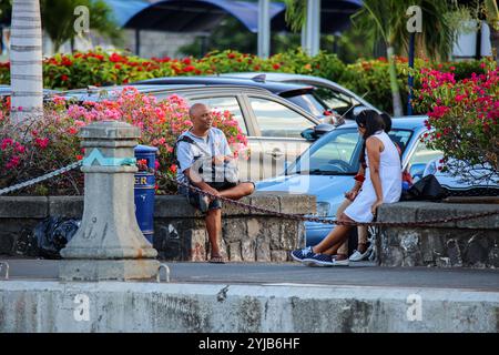 Ein Mann und eine Frau, Einheimische von Mauritius, sitzen auf einer Steinbank. Stockfoto