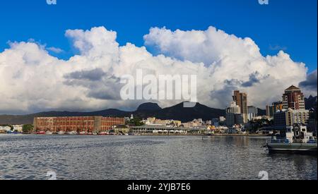 Das weitläufige Stadtbild von Port Louis, Mauritius, spiegelt sich in der großen Wasserfläche wider, die die urbane Landschaft vor einer natürlichen Kulisse zeigt. Stockfoto