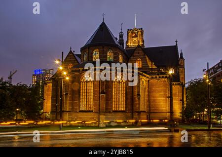 Rotterdam, Niederlande, 1. Oktober 2024: Kirche Sint Laurens, ältestes Gebäude im Stadtzentrum, in der blauen Stunde mit Lichtspuren auf der Nachbarschaft Stockfoto