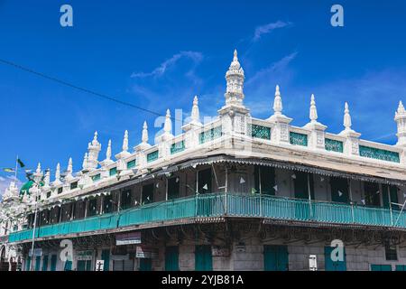 Dieses Foto zeigt ein altes Gebäude in Port Louis City, Mauritius, mit einem grünen Balkon und mehreren weißen Balkonen. Stockfoto