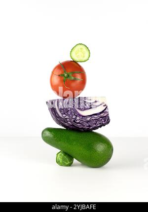 Gemüseausgleich auf dem Tisch. Ausgewogene Floating Food Balance von Avocado, rosenkohl, Tomaten und Rotkohl Stockfoto