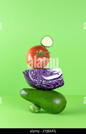 Gleichgewicht schwimmende Nahrung Gleichgewicht von Avocado, Purpurkohl auf grünem Hintergrund. Stockfoto