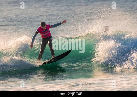 Ein junger Surfer, der auf einer Welle in Fistral in Newquay in Cornwall in Großbritannien in Europa reitet. Stockfoto