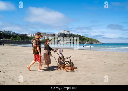 Eine Familie im Urlaub macht einen Spaziergang über den Strand von Towan bei Ebbe in Newquay in Cornwall in Großbritannien. Stockfoto