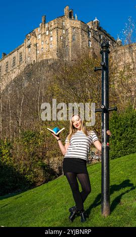 Edinburgh, Schottland, Großbritannien, 14. November 2024, Push the Boat Out: Die preisgekrönte Folk-Sängerin Iona Fyfe posiert mit einem Origami-Papierboot unter dem berühmten Edinburgh Castle, um Schottlands nationales Poetry-Festival zu fördern. Iona wird einen Abend mit Poesie-verschmolzenen Liedern in die Hauptrolle nehmen. Quelle: Sally Anderson/Alamy Live News Stockfoto