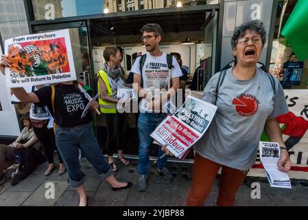 London, Großbritannien. Mai 2018. Die Demonstranten der Revolutionären Kommunistischen Gruppe und der Sieg der Intifada im Carphone Warehouse fordern ein Ende der britischen Unterstützung für Israel nach dem barbarischen Massaker der israelischen Scharfschützen an unbewaffneten Demonstranten, die am Großen Marsch der Rückkehr in Gaza teilnahmen, bei dem über 60 Menschen getötet und Tausende schwer verletzt wurden. Viele der Waffen, mit denen die Demonstranten getötet wurden, wurden vermutlich von britischen Rüstungsunternehmen geliefert. Der Protest begann vor einer Filiale der Barclays Bank, die große Investitionen in Israel tätigt, und setzte sich weiter in der Oxford Street fort, wobei er kurz hielt, um zu sprechen Stockfoto