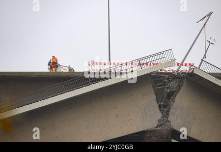 Dresden, Deutschland. November 2024. Ein Arbeiter fährt eine Baumaschine über den nicht eingestürzten Teil der Carola-Brücke vor den Trümmern der eingestürzten Brückenbrücke. Der westliche Abschnitt der Brücke mit Straßenbahnschienen, Radweg und Fußweg brach in der Nacht vom 11. September 2024 aus bisher unbekannten Gründen zusammen. Robert Michael/dpa/Alamy Live News Stockfoto