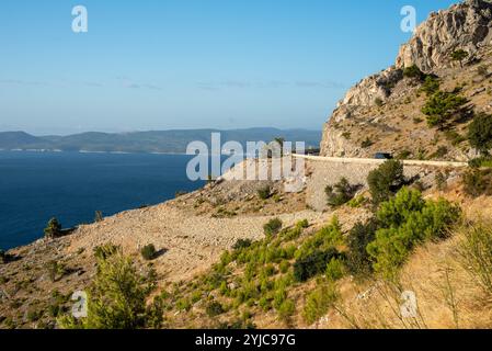 Bergstraße in der Region Dalmatien, Kroatien, schlängelt sich durch malerische Landschaften mit atemberaubendem Blick auf das zerklüftete Gelände und die Schönheit der Küste. A p Stockfoto