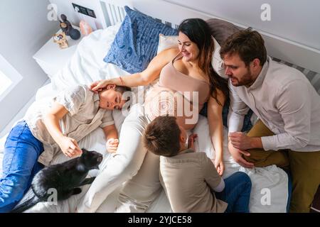 Die Familie der schwangeren Mutter mit ihren beiden Kindern, ihrem Ehemann und ihrer Katze Stockfoto