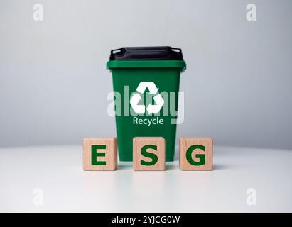 Grünes ESG-Symbol auf Holzblock mit Recyclingbehälter und Investition in nachhaltiges, umweltfreundliches Unternehmen. ESG-Konzept über Umwelt, Soziales und Gover Stockfoto