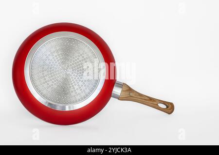 Bratpfanne aus roter Keramik auf weißem Hintergrund. Langlebige Bratpfanne. Antihaftpfanne. Frittieren ohne Öl. Stockfoto