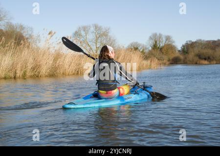 Man paddelt im Sit-on-Top Kajak flussaufwärts auf dem Yare in der Nähe von Postwick, Norwich, Norfolk, Broads National Park Stockfoto