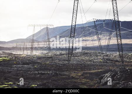 Hochspannungskabel an Polen, vor dem Hintergrund eines bewölkten Himmels. Die Leitungen sind mit Glasisolierung an den Masten befestigt. Die Linien werden verlaufen Stockfoto