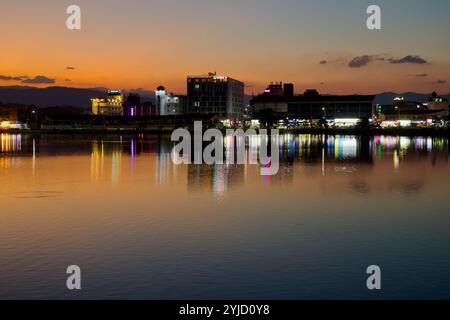 Gangneung, Südkorea - 3. November 2024: Ein atemberaubender Blick auf den Gyeongpodae Lake bei Sonnenuntergang mit lebendigen Reflexen der Stadtlichter, die die CA Stockfoto