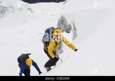 Bergsteiger Skitouren im Hinterland in den Bergen. Skitouren in hochalpiner Landschaft mit verschneiten Bäumen. Abenteuer Winter Extremsport. Stockfoto