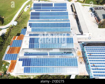 Solarpaneele, die auf dem Dach eines großen Industriegebäudes oder eines Lagers installiert sind. Industriegebäude auf der Landseite Sloweniens mit Wohnhaus h Stockfoto