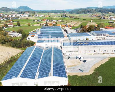 Solarpaneele, die auf dem Dach eines großen Industriegebäudes oder eines Lagers installiert sind. Industriegebäude auf der Landseite Sloweniens mit Wohnhaus h Stockfoto