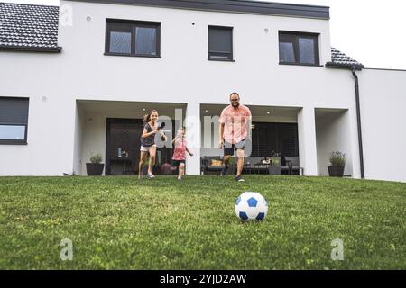 Glückliche kaukasische Familie mit vier Personen, Mutter Vater und Kinder zu Hause, draußen auf dem Gras spielen und drinnen im Wohnzimmer Spaß als fami haben Stockfoto