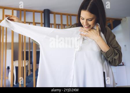 Junge kaukasische Frau erhält eine große Kiste mit ihren Online-Bestellungen. Frau, die das Paket öffnet und begeistert ist, das Zeug zu sehen, das sie gekauft hat. Stockfoto