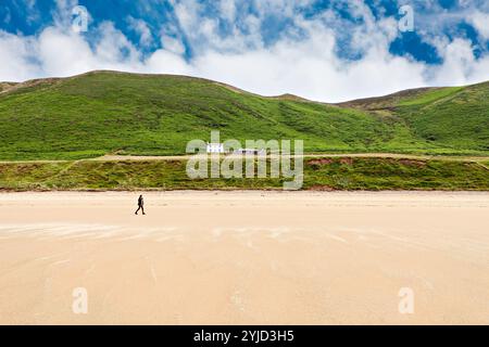 Frau, die am Sandstrand entlang läuft - Rhossili Bay, Gower Way, Wales Stockfoto